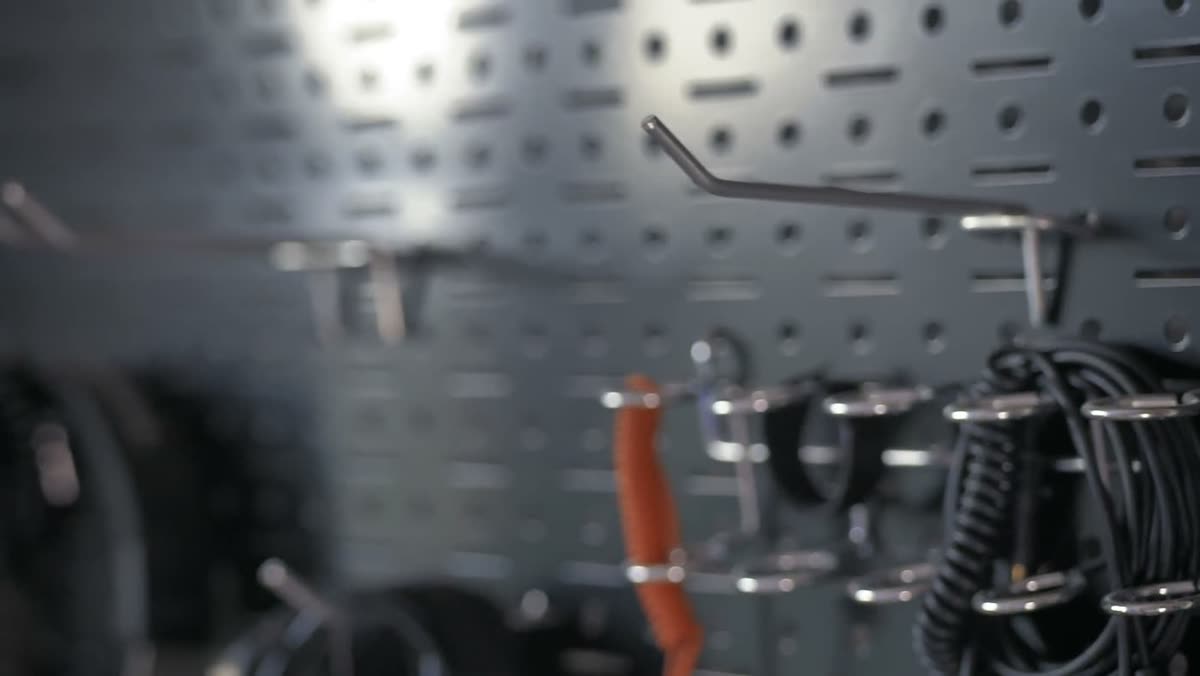 Coils of electrical wire hanging on a workshop pegboard